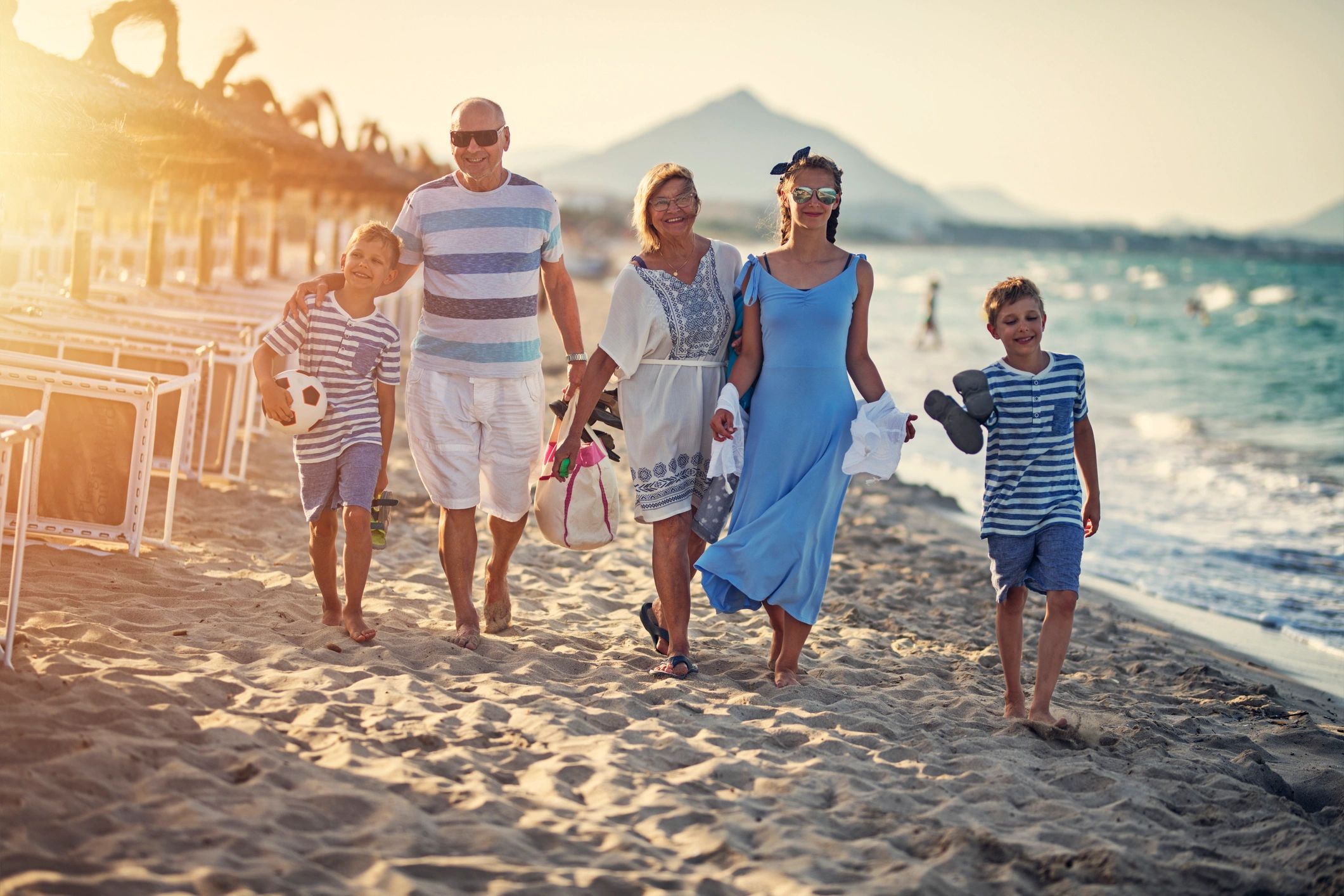 Family walking together along the beach at sunset