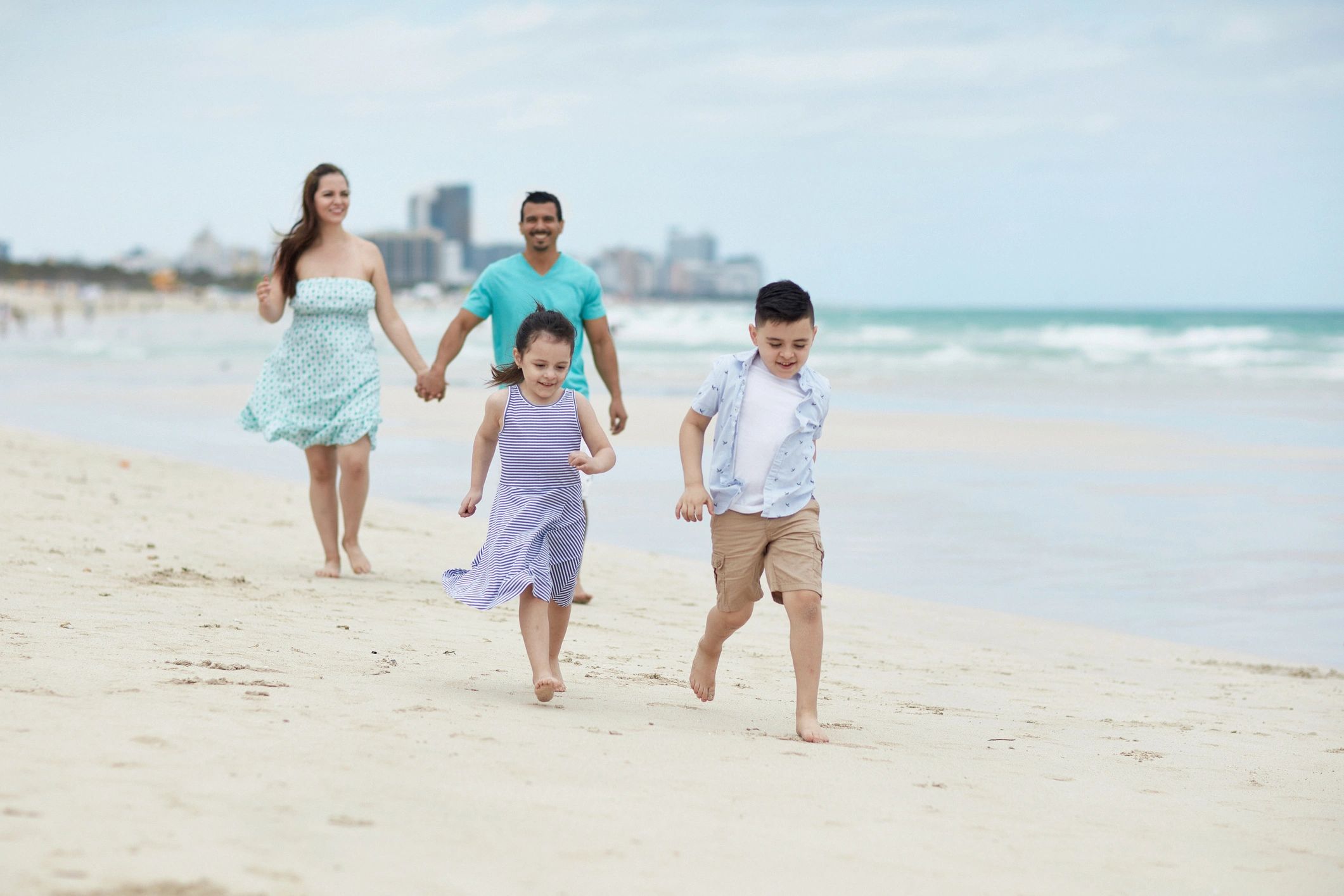 Young Hispanic Children Leading Parents on Beach Walk
