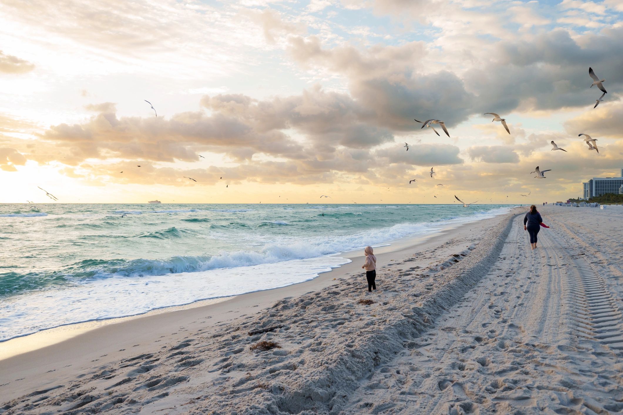 Child looking out at the ocean during sunset