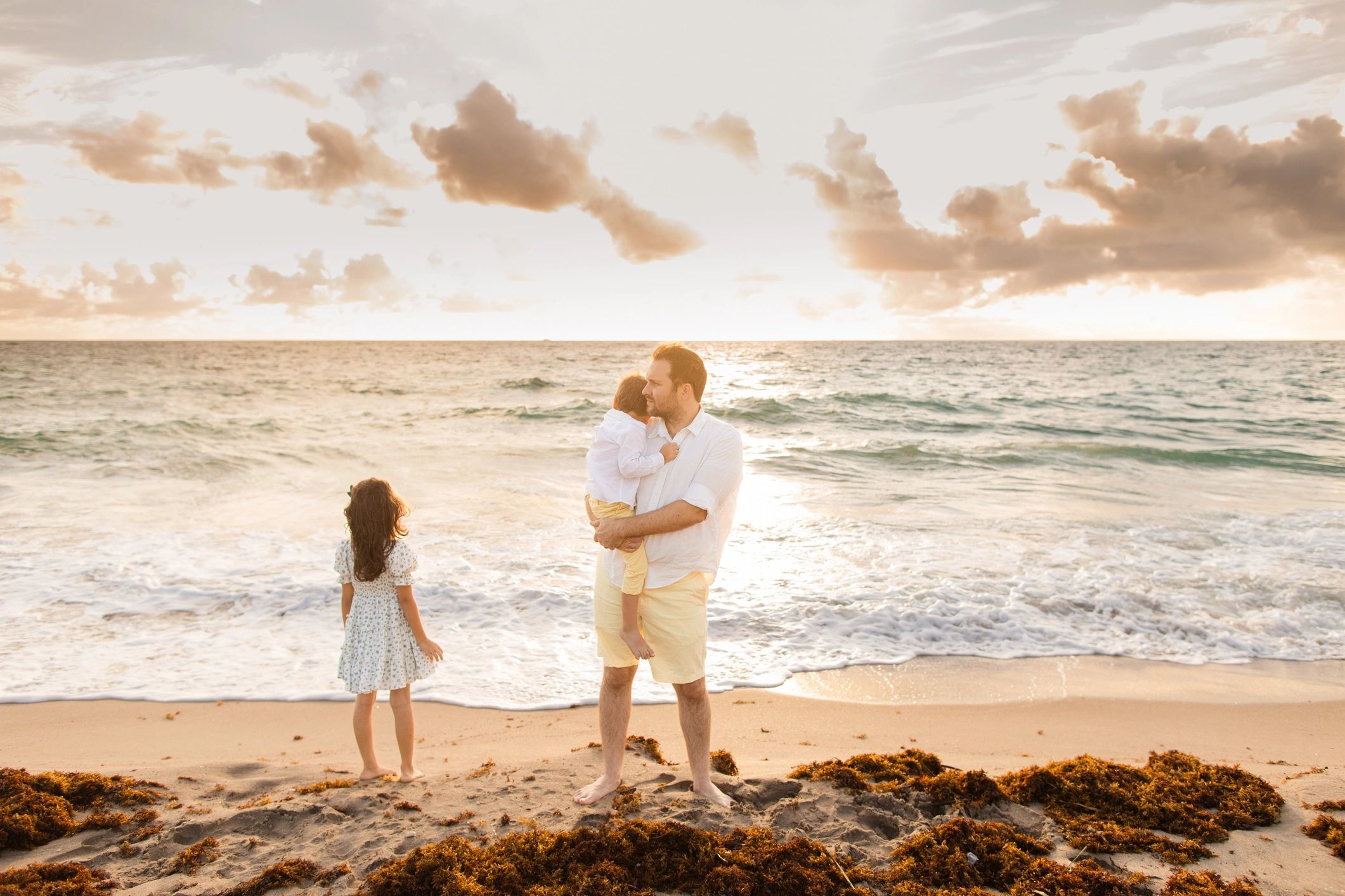 A 34-Year-Old American Father Standing by the Seashore with His 3-Year-Old Son & 6-Year-Old Daughter, Enjoying Peaceful Time Together During a Golden Sunrise on Palm Beach, Florida in the Summer of 2025