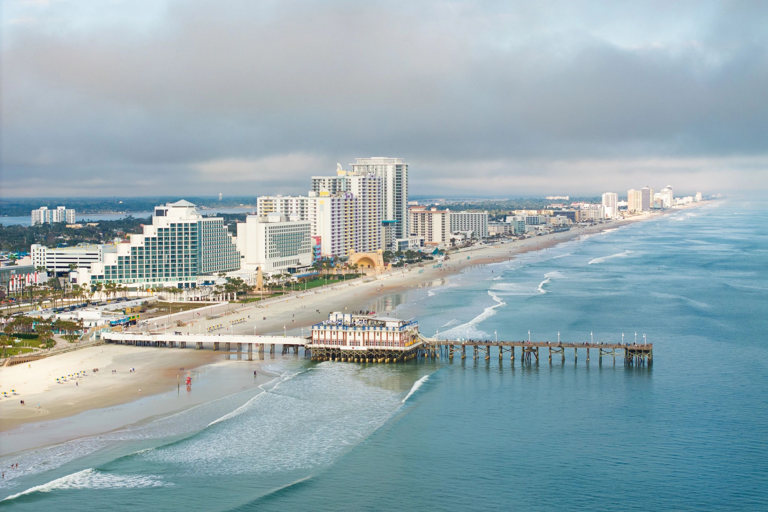 Aerial view of a wide sandy Florida beach with hotels and pier