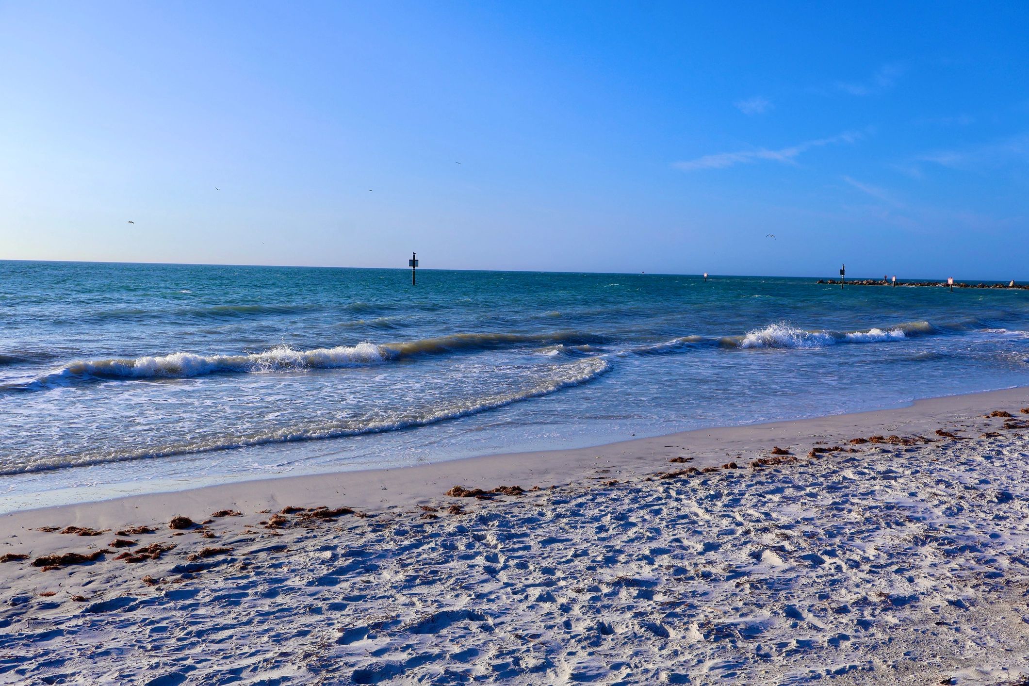 Calm sandy beach with gentle Gulf waves for Naples Beach inspiration